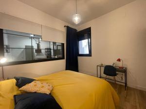 1 dormitorio con cama amarilla y escritorio en APARTAMENTOS SOL Y LUNA, en La Línea de la Concepción