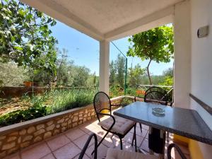 Un patio con una mesa y sillas en un balcón. en Apartments Marica, en Čižići