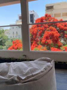a bed in a room with a window with red flowers at Boutique Penthouse by Weizmann - פנטהאוס בוטיק in Rechovot