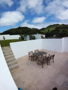 une table et des bancs au-dessus d'un mur blanc dans l'établissement Casa Malbusca, à Almagrinha
