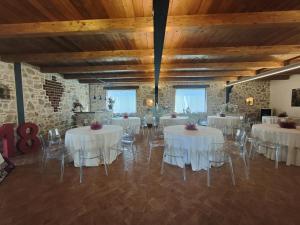 una habitación con mesas y sillas blancas en un edificio en Villa Proserpina, en Castel Ritaldi