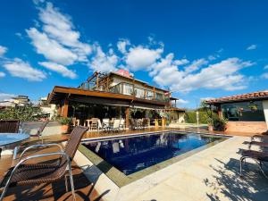 a house with a swimming pool in front of a house at Pousada Quintal da Lua in Capitólio