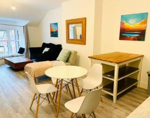 uma sala de estar com uma mesa e cadeiras e um sofá em Central modern 1 Bed 1 Bath flat em Woking