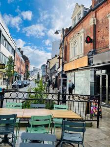 a patio with tables and chairs on a city street at Central modern 1 Bed 1 Bath flat in Woking