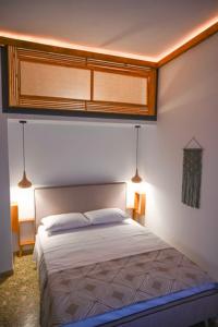 ein Schlafzimmer mit einem Bett mit zwei Leuchten in der Unterkunft Elia’s Guest House in Koríni