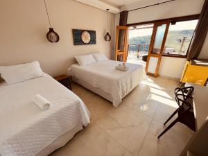 a bedroom with two beds and a balcony at Pousada Quintal da Lua in Capitólio +248 photos