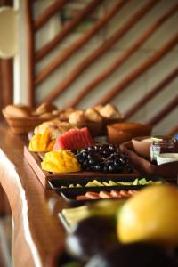 einen Tisch mit verschiedenen Brotsorten und Früchten in der Unterkunft Chalé Ingrid Ar condicionado Pousada 35knots Brasil in Luis Correia + 4 Fotos