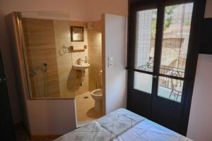 a bedroom with a bathroom with a shower and a toilet at Elia’s Guest House in Koríni