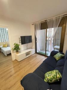 a living room with a blue couch and a television at Apartamento en la costa del Maresme in Pineda de Mar