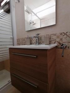 ein Bad mit einem Waschbecken und einem Spiegel in der Unterkunft Sabrina in Poggiardo