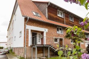 Cette maison en briques dispose d'une terrasse couverte et d'un balcon. dans l'établissement Stilvolles Mikroapartment in Kehl Goldscheuer - 1A Guesthouse, à Kehl