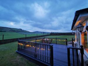 una terraza con una valla con luces. en Private peacefull pet friendly converted country cottage 
