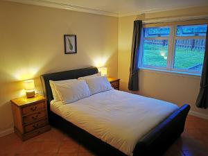 um quarto com uma cama, uma mesa de cabeceira e uma janela em Private peacefull pet friendly converted country cottage 
