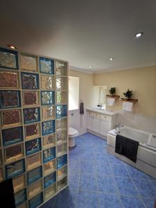 y baño con bañera, aseo y lavamanos. en Private peacefull pet friendly converted country cottage 