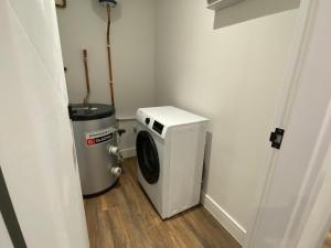 倫敦的住宿－7 - West London Brand New Loft，洗衣房配有洗衣机和垃圾桶