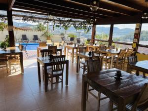 a restaurant with tables and chairs and a pool at Pousada Quintal da Lua in Capitólio