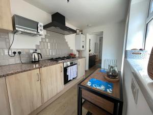 a kitchen with wooden cabinets and a stove top oven at Nottingham Home Stay in Nottingham