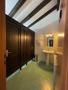 La salle de bains est pourvue d'un lavabo, de toilettes et d'un miroir. dans l'établissement Pensiunea La Maison, à Bran