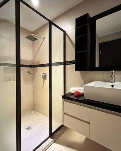 a bathroom with a shower and a sink and a mirror at Garden Apartments in Nadi