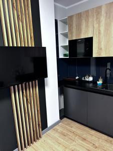 eine Küche mit einer schwarzen Theke und einer Mikrowelle in der Unterkunft Apartament Walczaka 47 MIEJSCE PARKINGOWE in Gorzów Wielkopolski