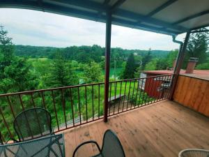a balcony with chairs and a view of the woods at Kuća Schunko in Duga Resa