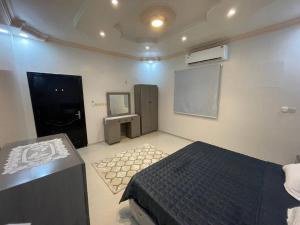 1 dormitorio con cama y pizarra en la pared en شقة واسعة بدخول ذاتي en Medina