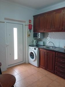 Una cocina con lavadora al lado de una puerta. en Burgau Mar, en Burgau