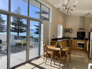 a kitchen with a table and chairs and a large window at Kaikoura Waterfront Apartments in Kaikoura