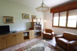 een woonkamer met een tv en een bank en een stoel bij [cav Maura] relax toscana in Crocina