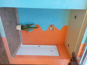 cabina de ducha con pared naranja y azul en Departamentos Lathine en San José