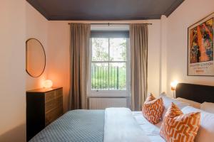 a bedroom with a bed and a window at Lux and Spacious 4 bedroom apt Camden in London