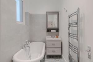 a white bathroom with a sink and a mirror at Lux and Spacious 4 bedroom apt Camden in London