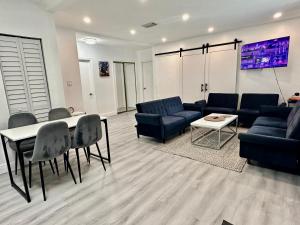 uma sala de estar com um sofá, uma mesa e cadeiras em World Connect Miami em Miami