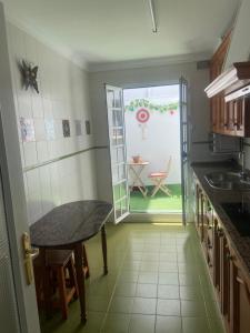 uma cozinha com uma mesa e uma porta para um quintal em PISO ATuN em Barbate