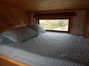 Bett in einem kleinen Zimmer mit Fenster in der Unterkunft Mini Casa Villa De Leyva in Sáchica