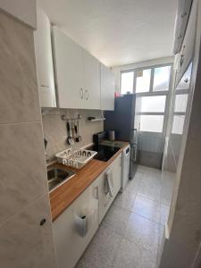 una cocina con armarios blancos y fregadero en Beato Typical House, en Lisboa