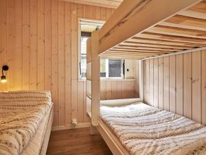 a bedroom with a bunk bed in a room with wooden walls at Holiday home Aakirkeby II in Vester Sømarken