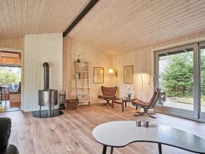 a living room with a fireplace and a table at Holiday home Aakirkeby II in Vester Sømarken