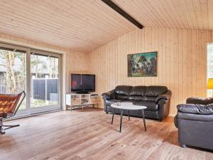 a living room with leather furniture and a tv at Holiday home Aakirkeby II in Vester Sømarken