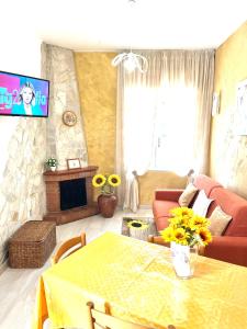 ein Wohnzimmer mit einem Tisch und einem TV in der Unterkunft Minù house in Scalea