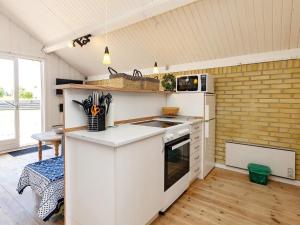 a kitchen with white cabinets and a counter top at Two-Bedroom Holiday home in Askeby 2 in Askeby