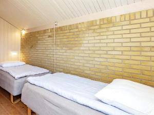 two beds in a room with a brick wall at Two-Bedroom Holiday home in Askeby 2 in Askeby