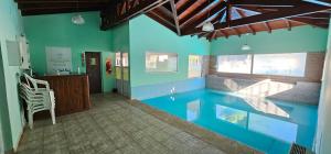 una casa con piscina en medio de una habitación en Posada Spa La Arabela en Huerta Grande