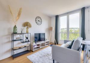 een woonkamer met een witte bank en een tv bij Studio proche paris la défense parking privé in Rueil-Malmaison