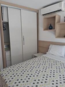 a small bedroom with a bed and sliding glass doors at LIV INN Apartamento na Beira-Mar Fortaleza in Fortaleza