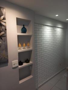 una stanza con un muro di mattoni e scaffali con vasi di LIV INN Apartamento na Beira-Mar Fortaleza a Fortaleza
