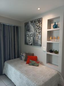 una camera da letto con un letto con una statua sul muro di LIV INN Apartamento na Beira-Mar Fortaleza a Fortaleza