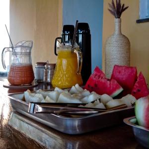 un vassoio di prodotti alimentari con frutta e succo su un tavolo di Pousada Diadorim a Sao Domingos de Goias
