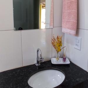 a bathroom counter with a sink and a mirror at Pousada Diadorim in Sao Domingos de Goias