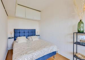 een slaapkamer met een bed met een blauw hoofdeinde bij Studio proche paris la défense parking privé in Rueil-Malmaison